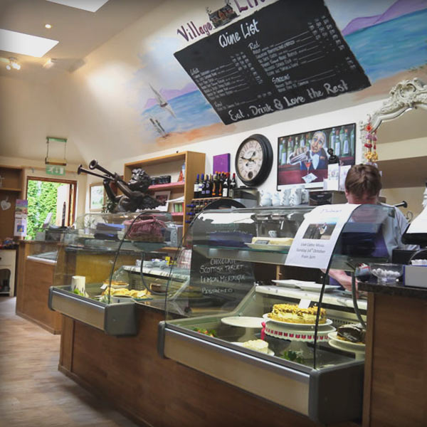 The village Rest shop counter with restaurant staff member working